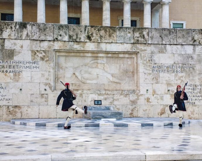 Traditional Evzone guards in ceremonial attire at the Tomb of the Unknown Soldier in Athens.